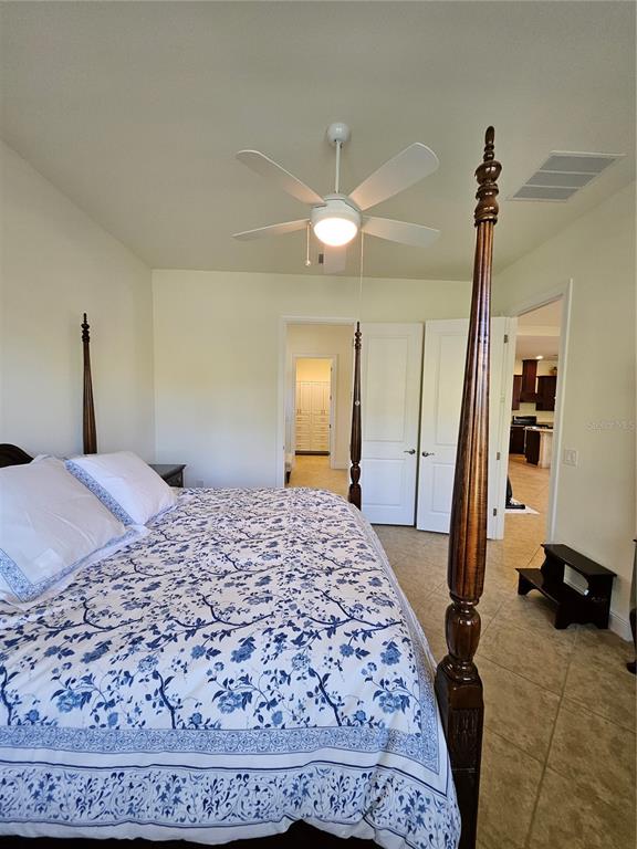 1283 Manado Drive Naples, FL 34113 - Photo 24 of 48 a bedroom with a bed and a dresser