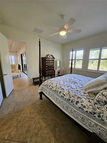 a bed sitting in a spacious bedroom next to a window and a larger closet