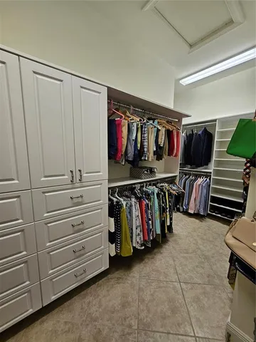 a view of walk in closet with clothes and shoes
