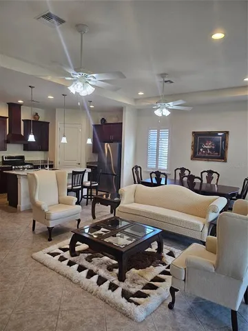 a living room with furniture a flat screen tv and kitchen view