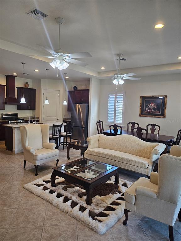1283 Manado Drive Naples, FL 34113 - Photo 9 of 48 a living room with furniture a flat screen tv and kitchen view