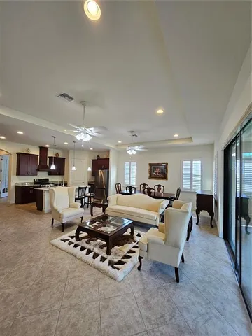 a living room with furniture and kitchen view