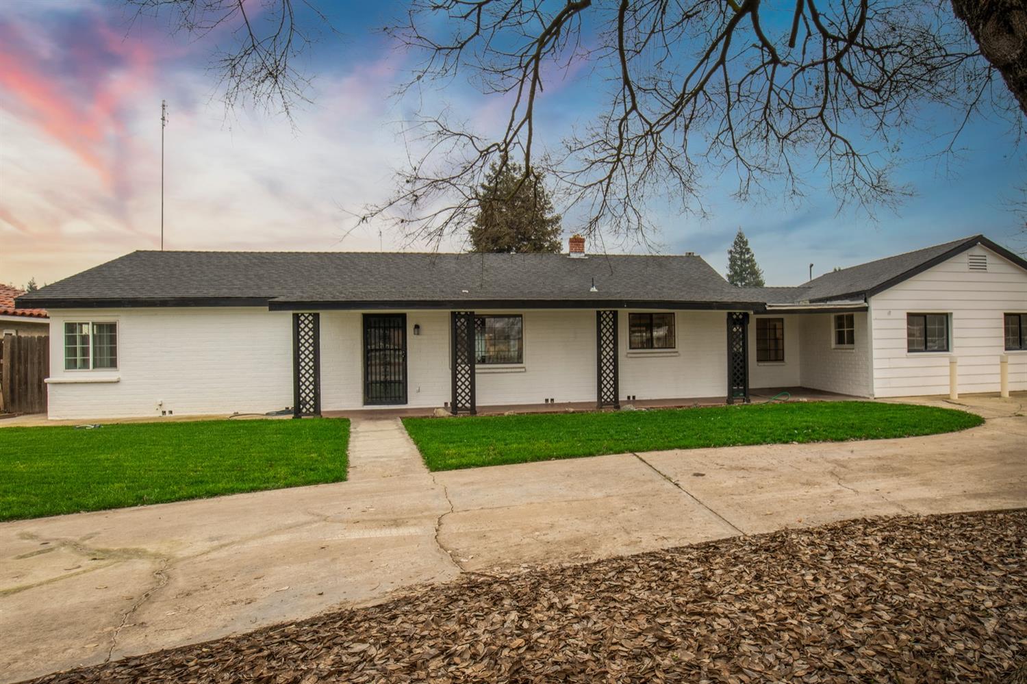 1322 North Reed Avenue Reedley, CA 93654 - Photo 1 of 54 a front view of a house with a yard and garage