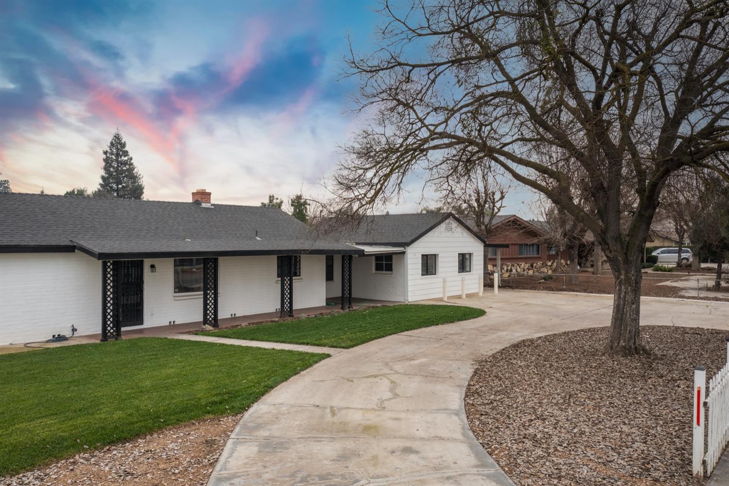 1322 North Reed Avenue Reedley, CA 93654 - Photo 2 of 54 a front view of a house with a garden and yard