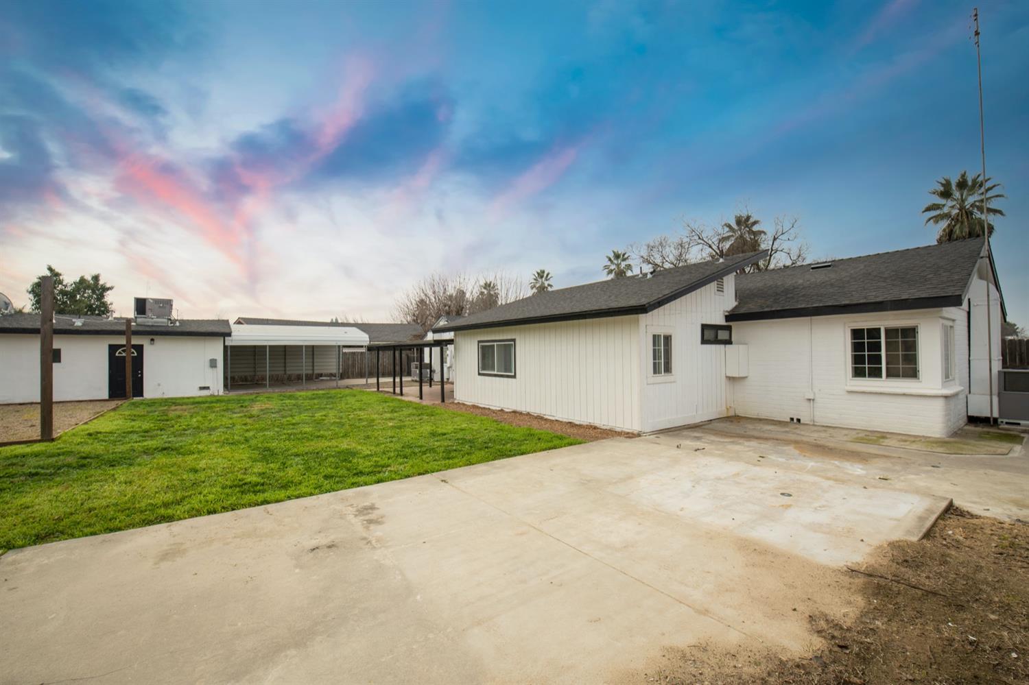 1322 North Reed Avenue Reedley, CA 93654 - Photo 42 of 54 a view of a house with a backyard and a garage