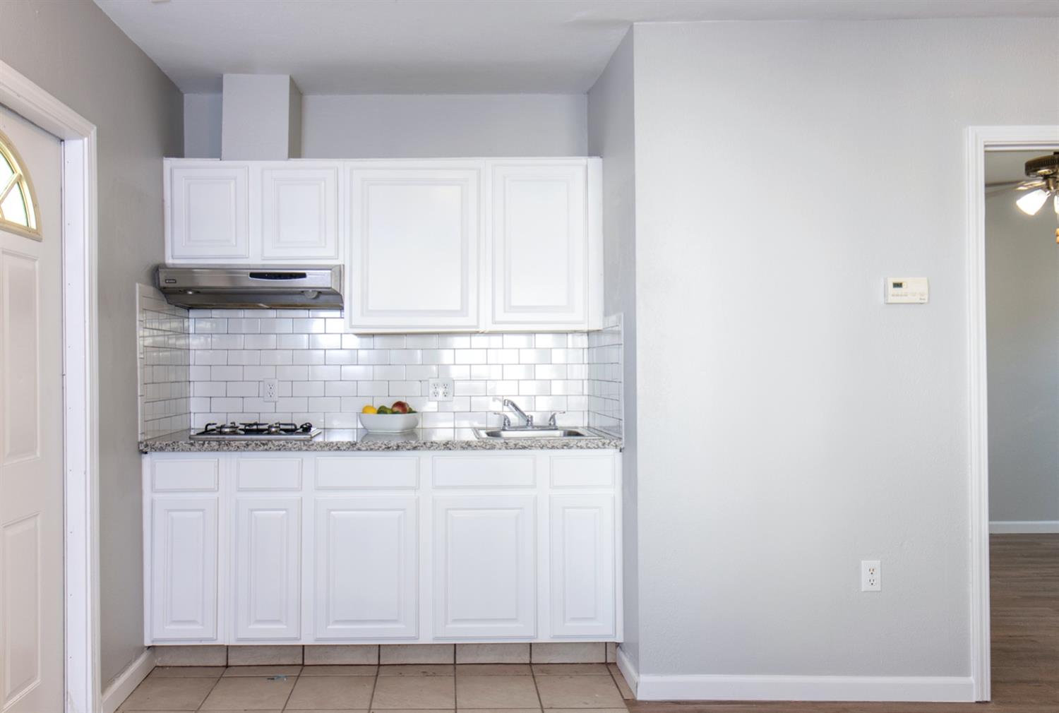 1322 North Reed Avenue Reedley, CA 93654 - Photo 45 of 54 a kitchen with granite countertop white cabinets and window