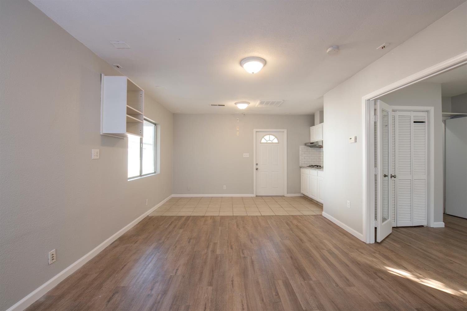 1322 North Reed Avenue Reedley, CA 93654 - Photo 47 of 54 an empty room with wooden floor and windows