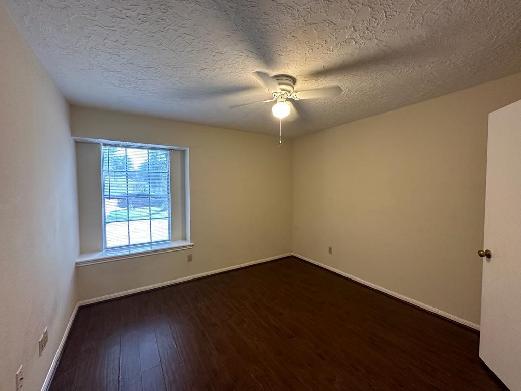 239 Kings Way Stafford, TX 77477 - Photo 21 of 24 a view of empty room with wooden floor and fan