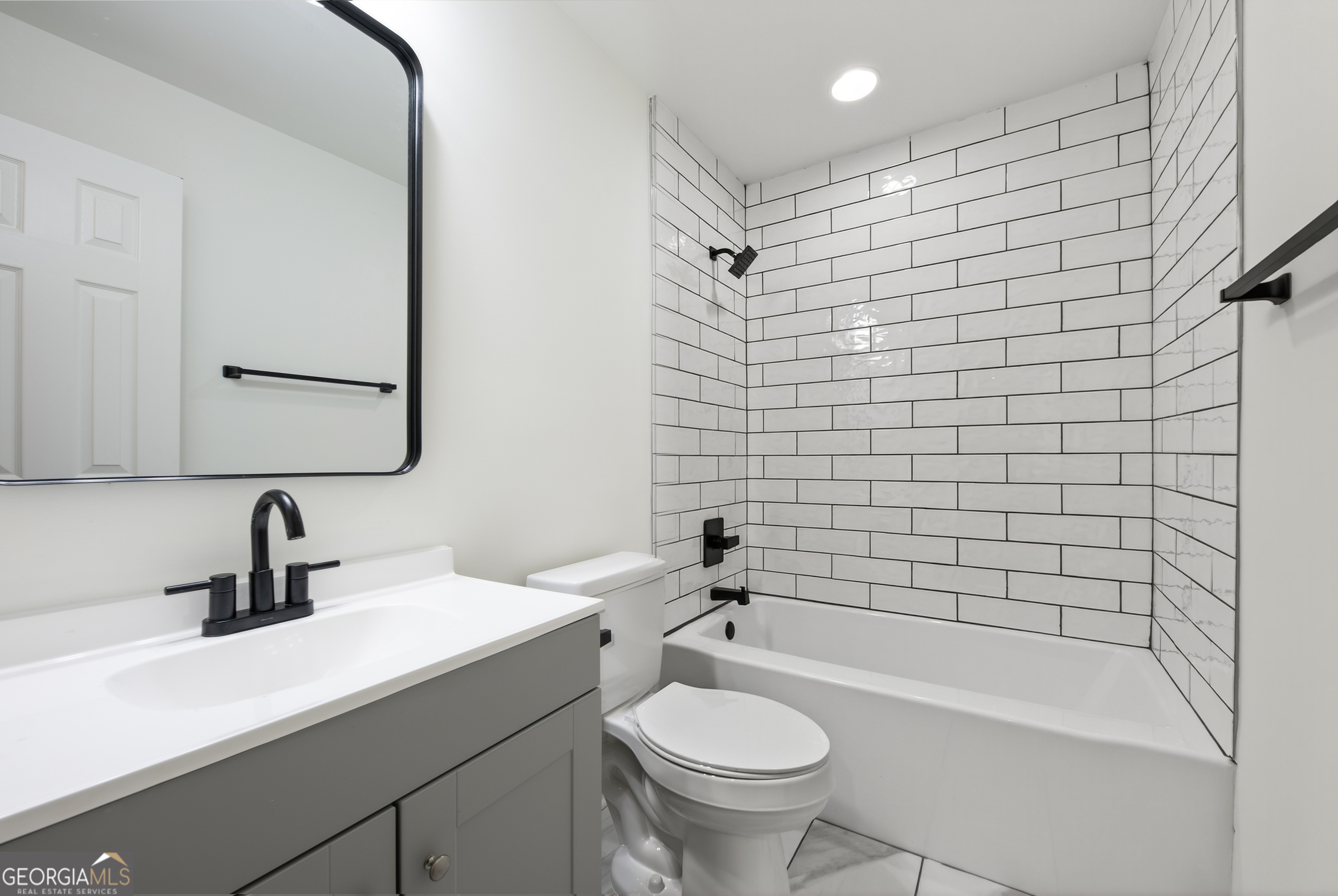 491 Vine Street, Unit A Madison, GA 30650 - Photo 13 of 20 a bathroom with a sink toilet a mirror and shower