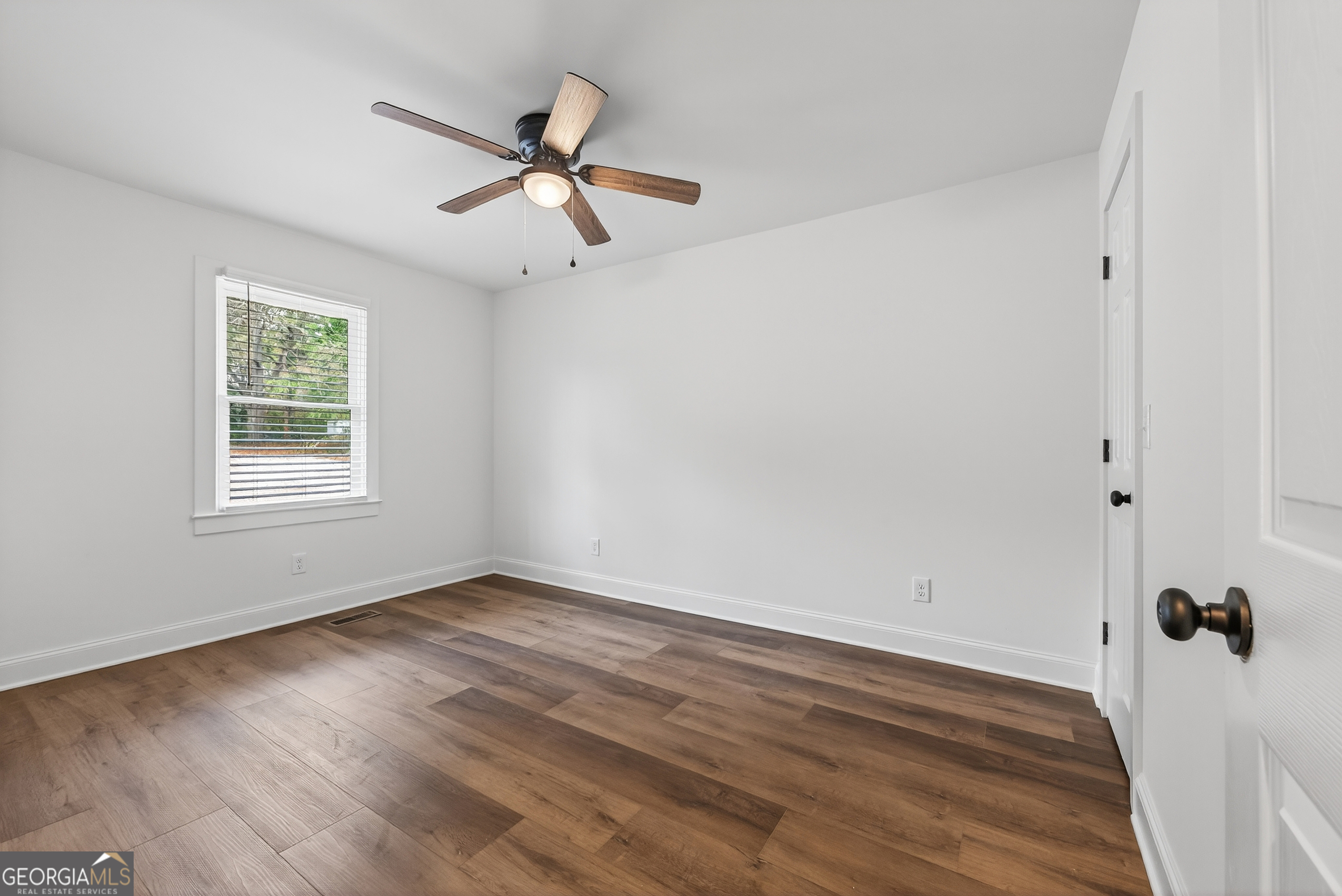 491 Vine Street, Unit A Madison, GA 30650 - Photo 14 of 20 wooden floor in an empty room with a window