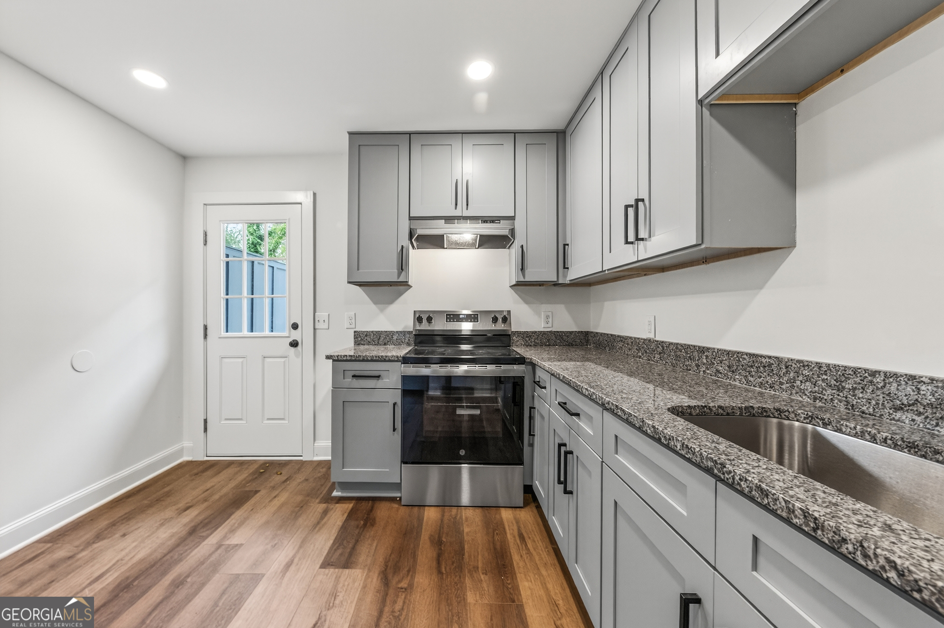 491 Vine Street, Unit A Madison, GA 30650 - Photo 8 of 20 a kitchen with a stove cabinets and refrigerator