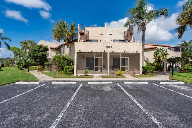 a view of a white house with a yard and plants