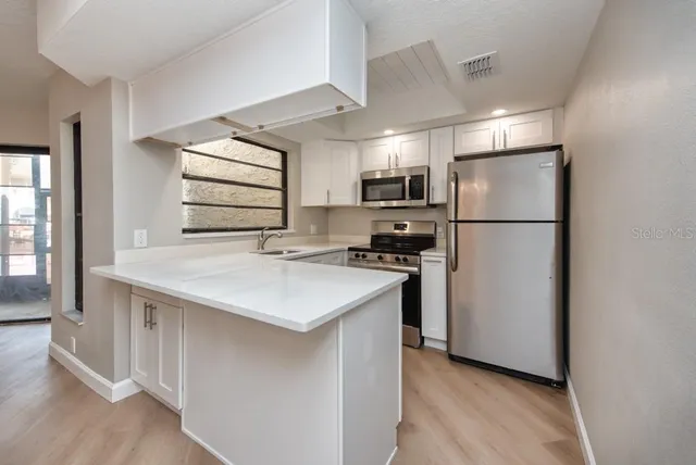 a kitchen with refrigerator cabinets and a sink