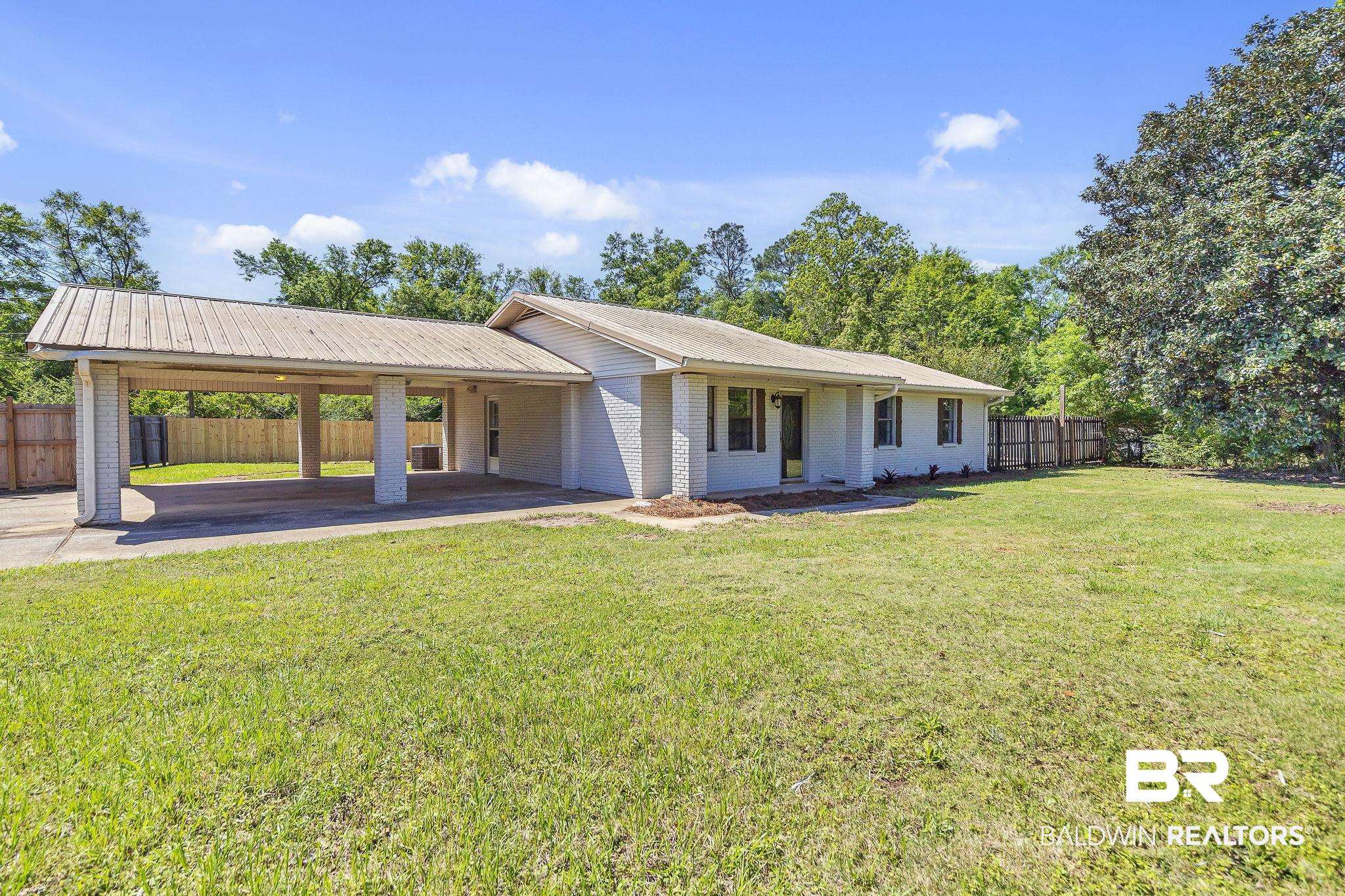 11964 Stroh Road Daphne, AL 36527 - Photo 6 of 58 View of front of house with brick siding, a front lawn, fence, and an attached carport