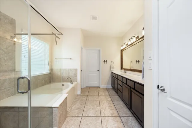 a spacious bathroom with a shower a sink and a mirror