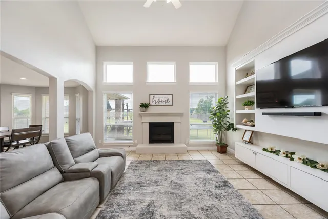 a living room with furniture a flat screen tv and a fireplace