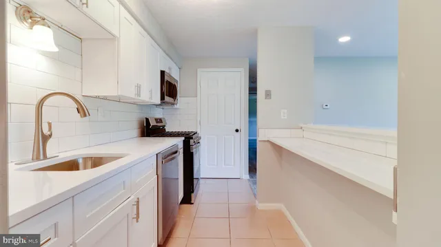a kitchen with stainless steel appliances granite countertop a sink and a stove
