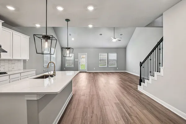 a kitchen with wooden floors sink and cabinets