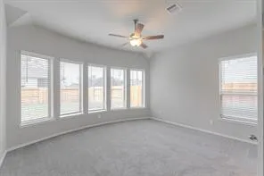 a view of an empty room with chandelier fan and fire place