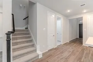 a view of a hallway with wooden floor and entryway