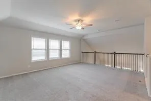 an empty room with chandelier fan and windows