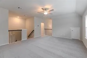 a view of an empty room with a chandelier fan and a window