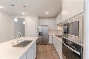 a kitchen with stainless steel appliances a sink stove and refrigerator