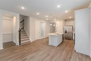 a view of a kitchen with wooden floor and electronic appliances