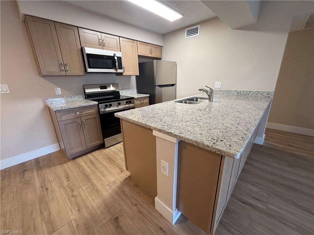5319 Summerlin Road, Unit 1916 Fort Myers, FL 33919 - Photo 2 of 8 a kitchen with a sink a microwave a stove and refrigerator