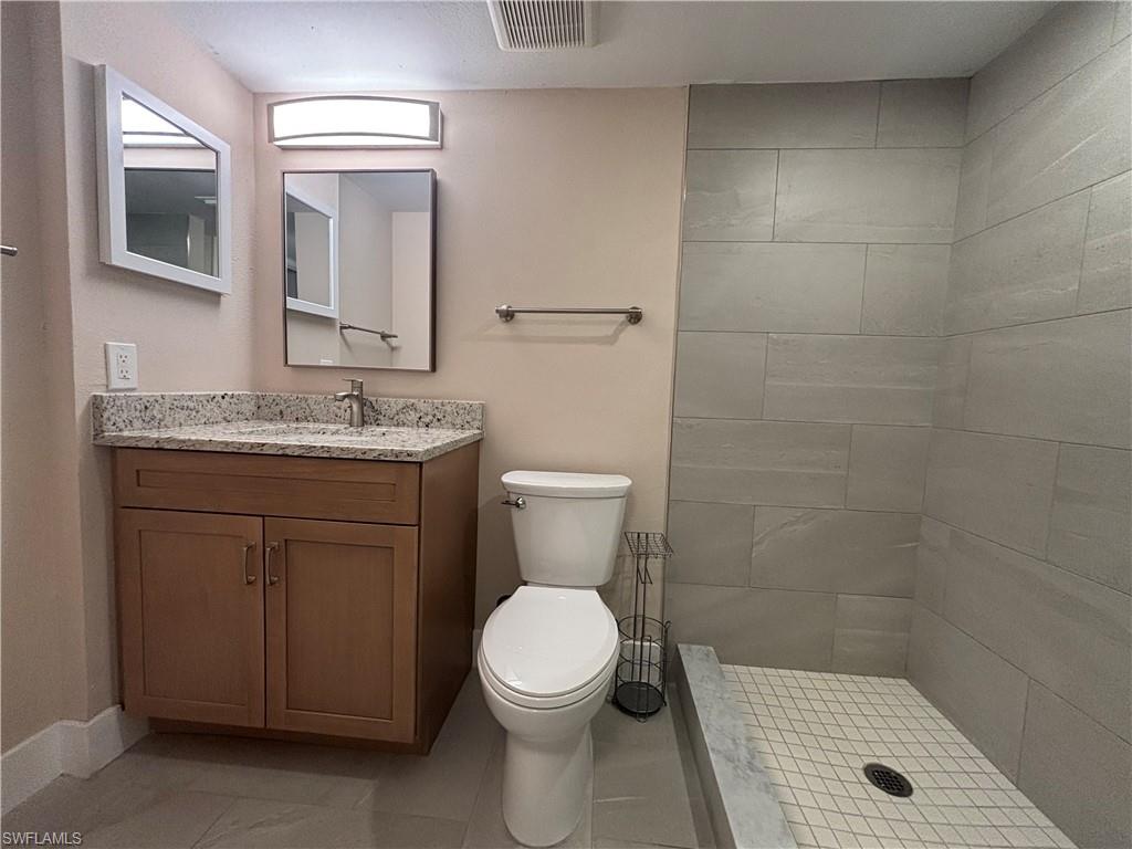 5319 Summerlin Road, Unit 1916 Fort Myers, FL 33919 - Photo 4 of 8 a bathroom with a granite countertop toilet sink and mirror