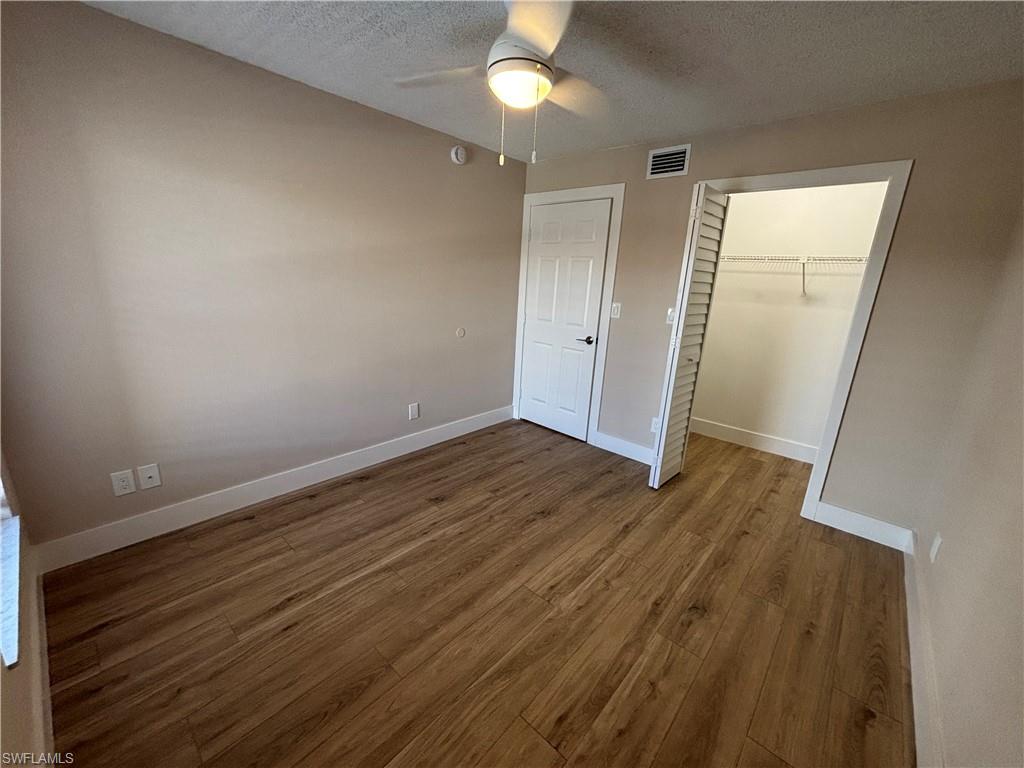 5319 Summerlin Road, Unit 1916 Fort Myers, FL 33919 - Photo 7 of 8 wooden floor in an empty room with a window