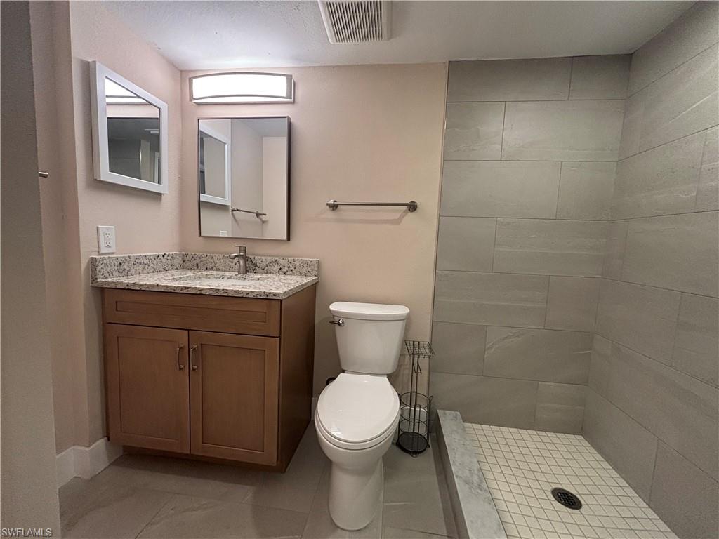 5319 Summerlin Road, Unit 1916 Fort Myers, FL 33919 - Photo 8 of 8 a bathroom with a granite countertop toilet a sink and mirror