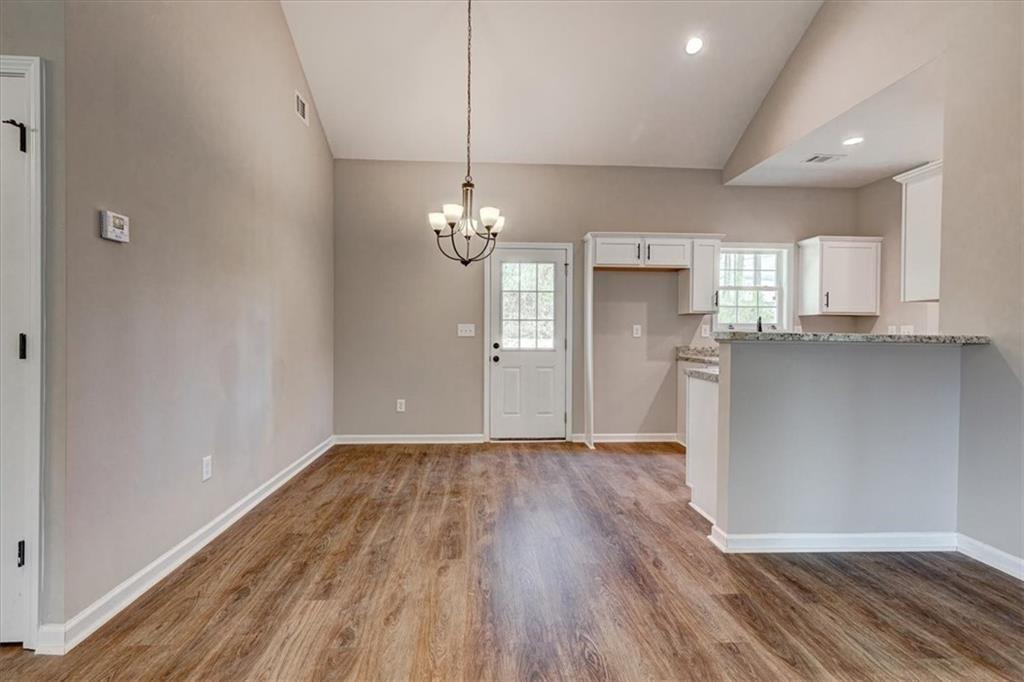 201 Loftis Road Temple, GA 30179 - Photo 6 of 14 an empty room with wooden floor and kitchen view