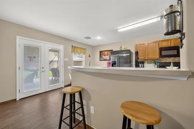 a kitchen with stainless steel appliances a microwave a stove and white cabinets with wooden floor