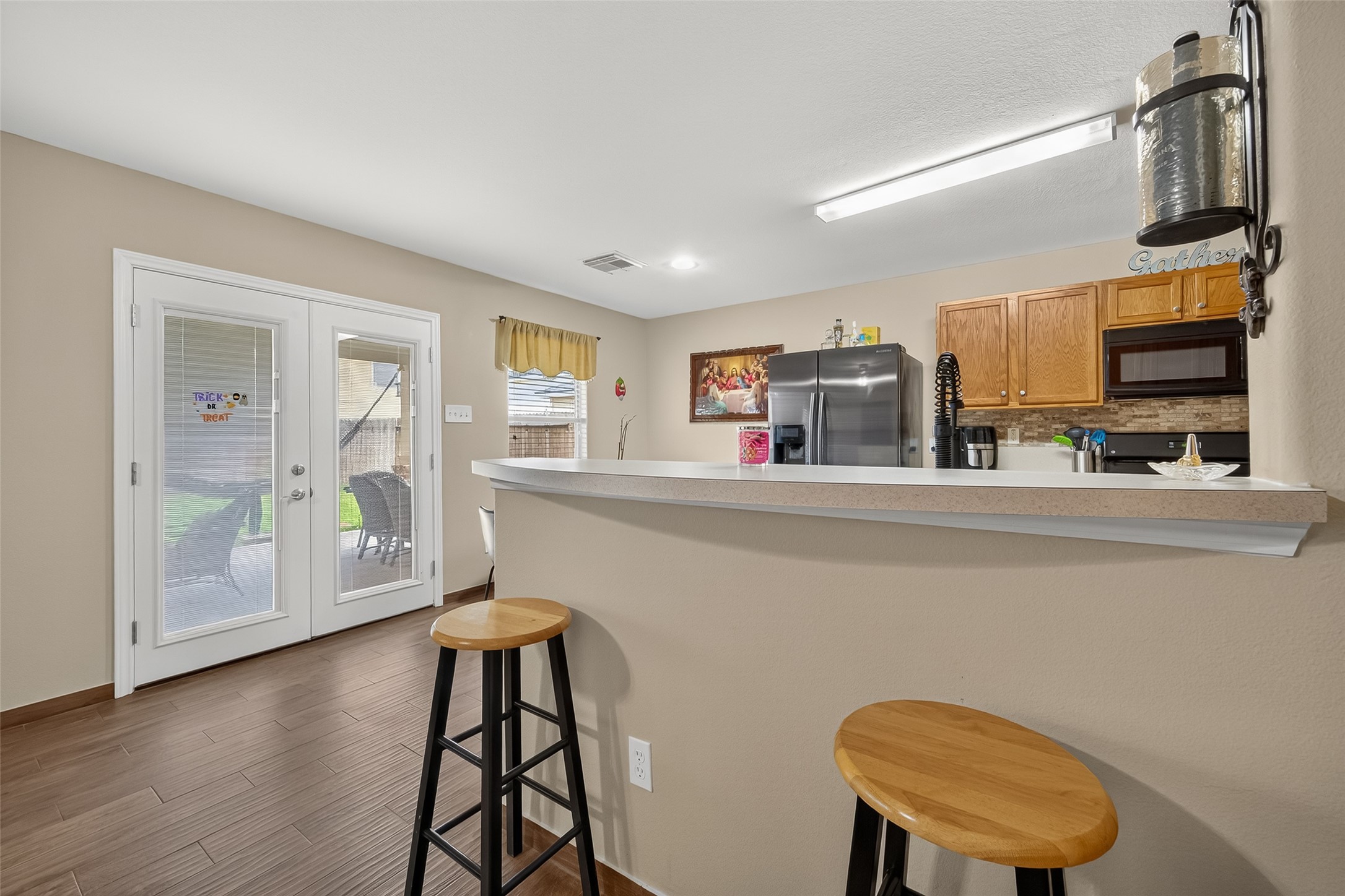 8311 Tartan Court Rosharon, TX 77583 - Photo 13 of 48 a kitchen with stainless steel appliances a microwave a stove and white cabinets with wooden floor