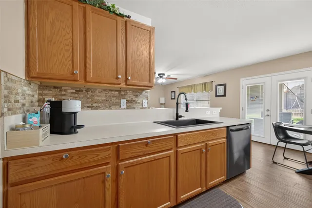 a kitchen with stainless steel appliances granite countertop a sink a stove and cabinets