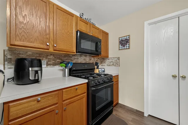 a kitchen with stainless steel appliances granite countertop a stove a sink and a microwave