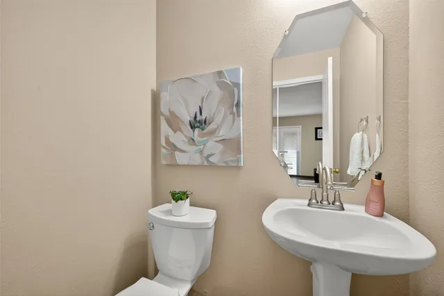 a bathroom with a toilet a sink and mirror