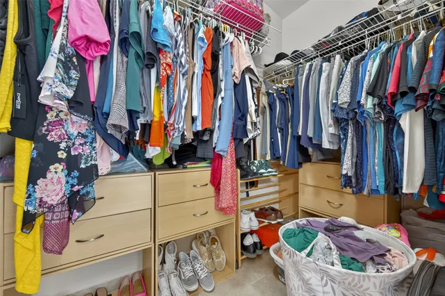 a view of walk in closet with clothes and shoes
