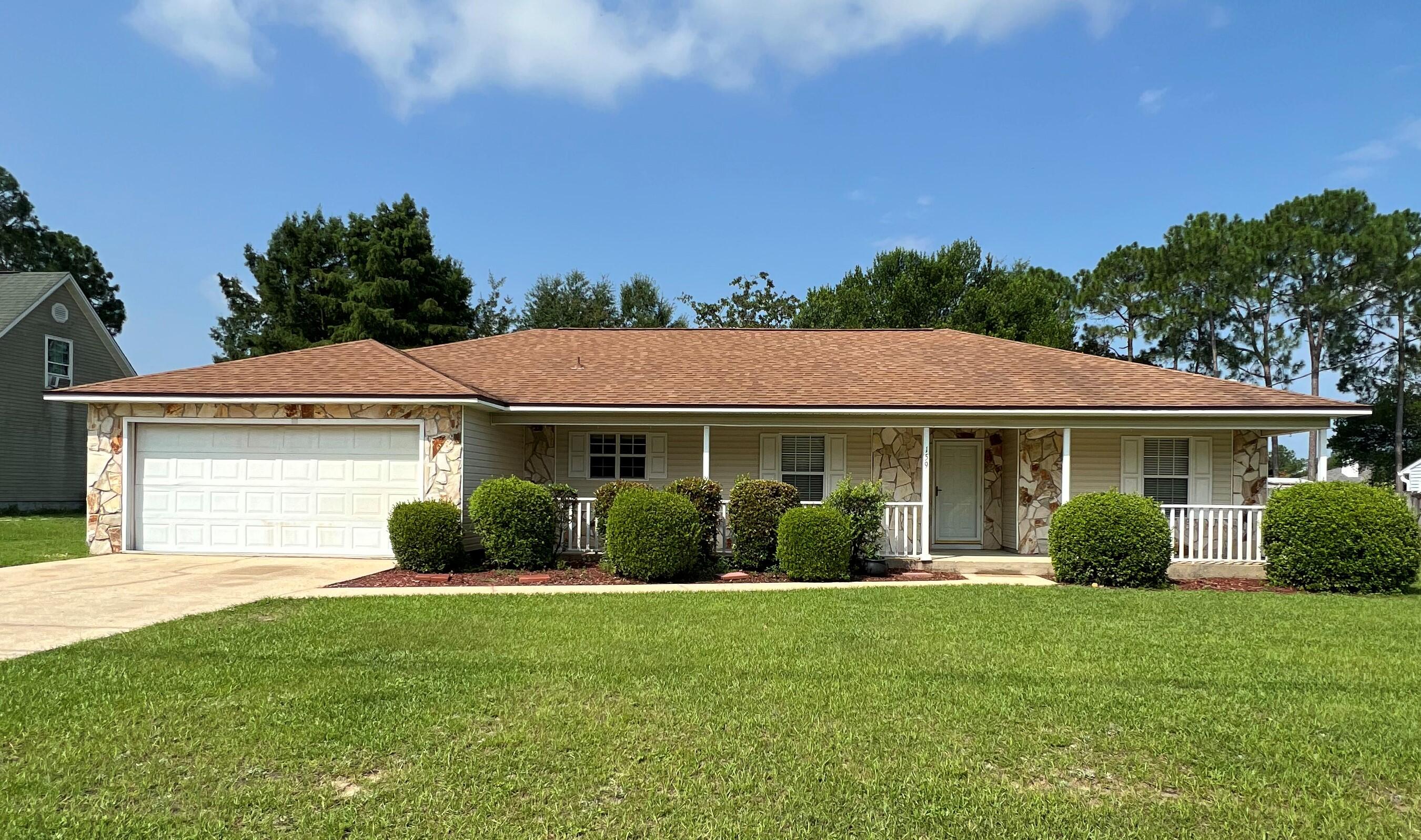 a view of a house with yard and a garden