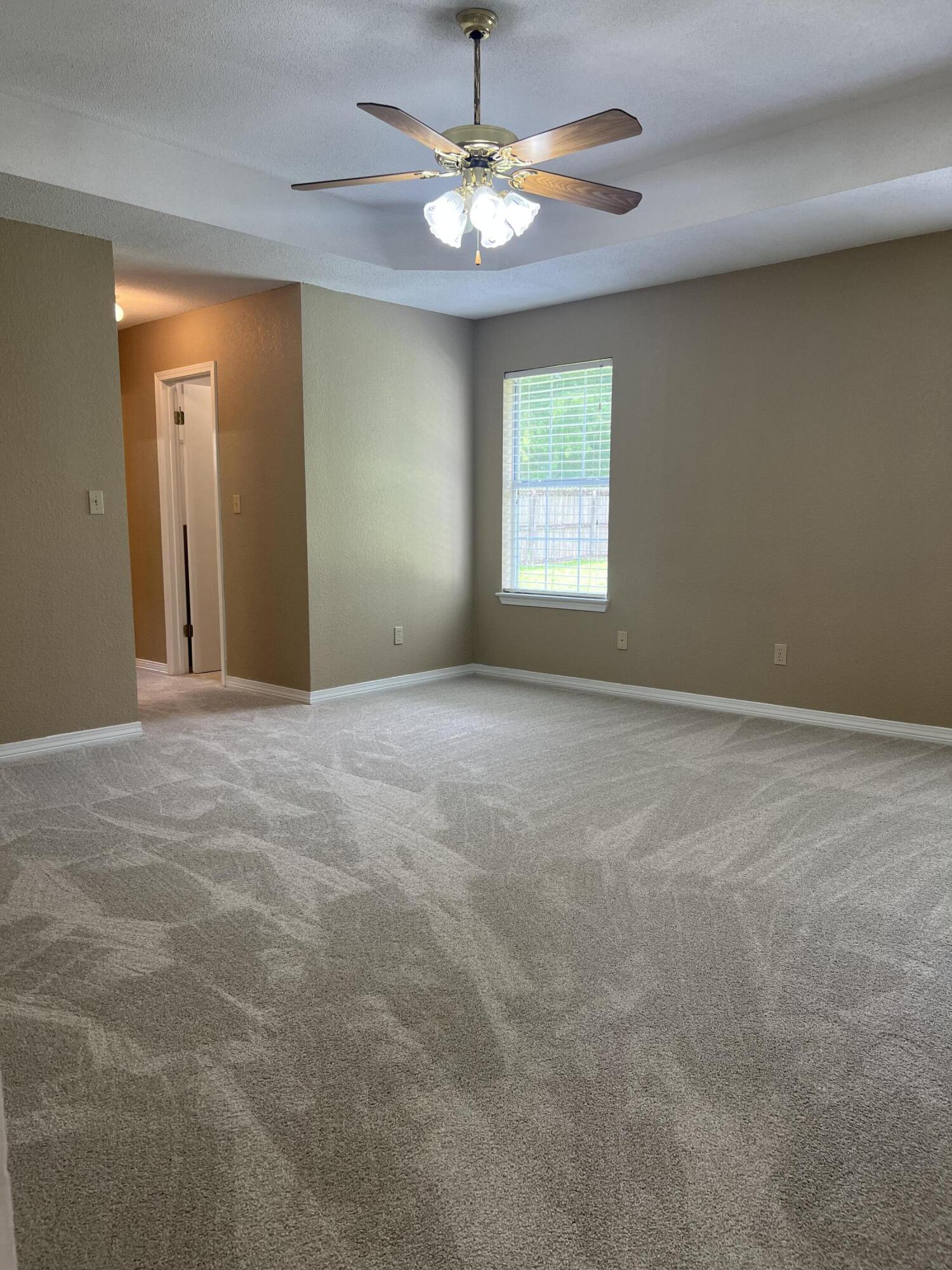 159 Nun Drive Crestview, FL 32536 - Photo 13 of 27 en empty room with windows and chandelier fan
