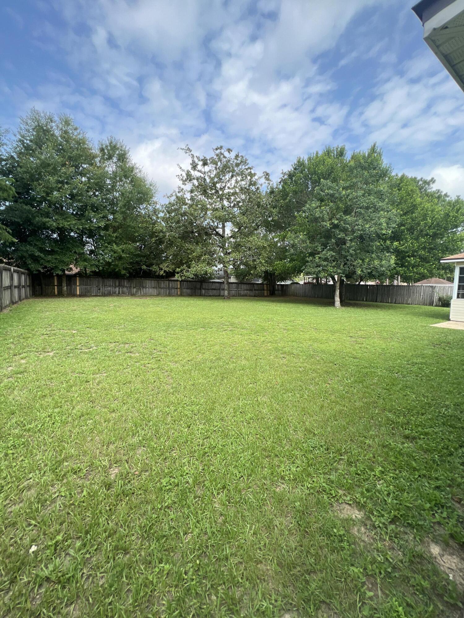 159 Nun Drive Crestview, FL 32536 - Photo 25 of 27 a view of a big yard with a house in the background