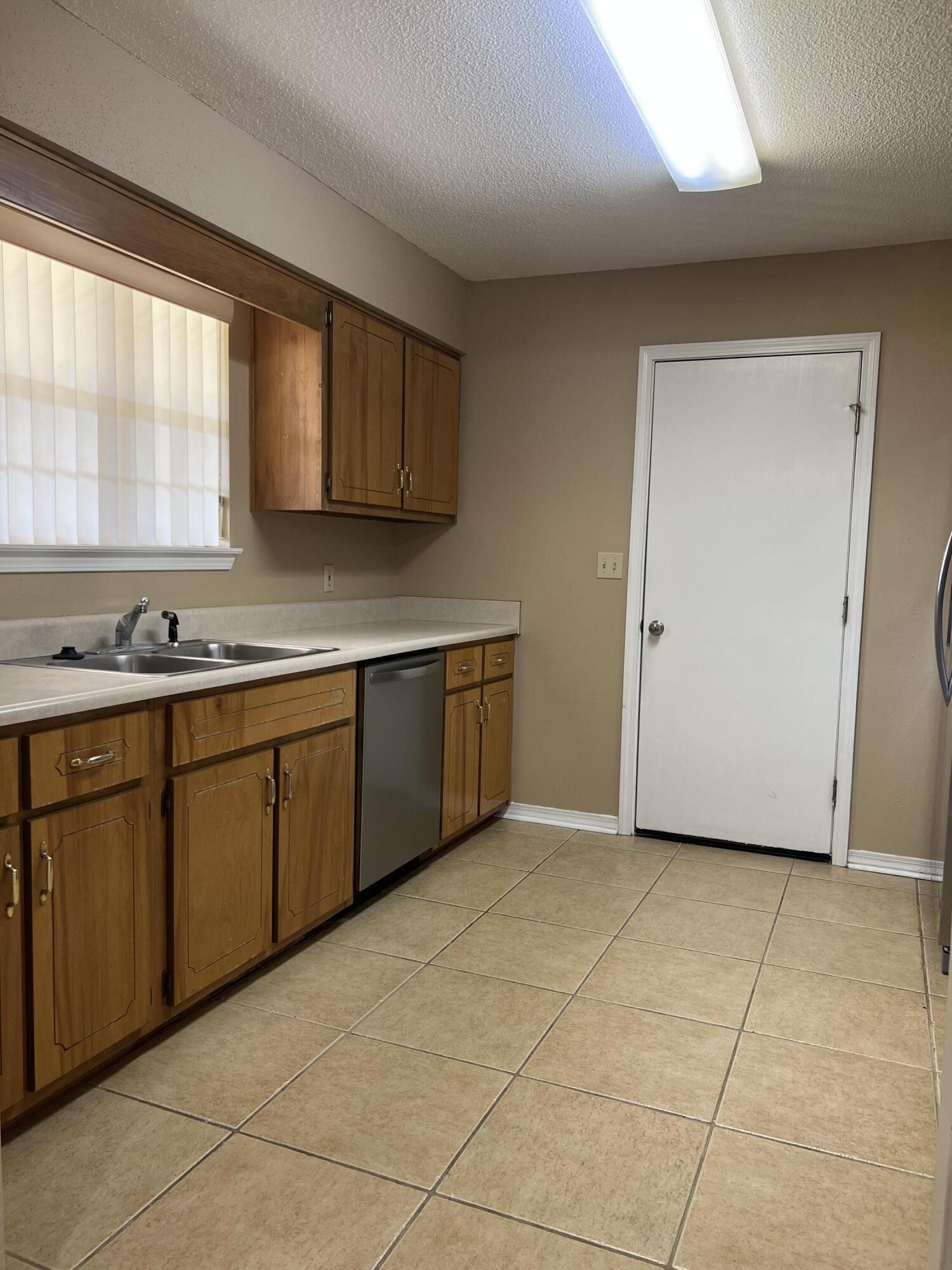 159 Nun Drive Crestview, FL 32536 - Photo 6 of 27 a kitchen with stainless steel appliances a sink a stove a refrigerator a window and cabinets