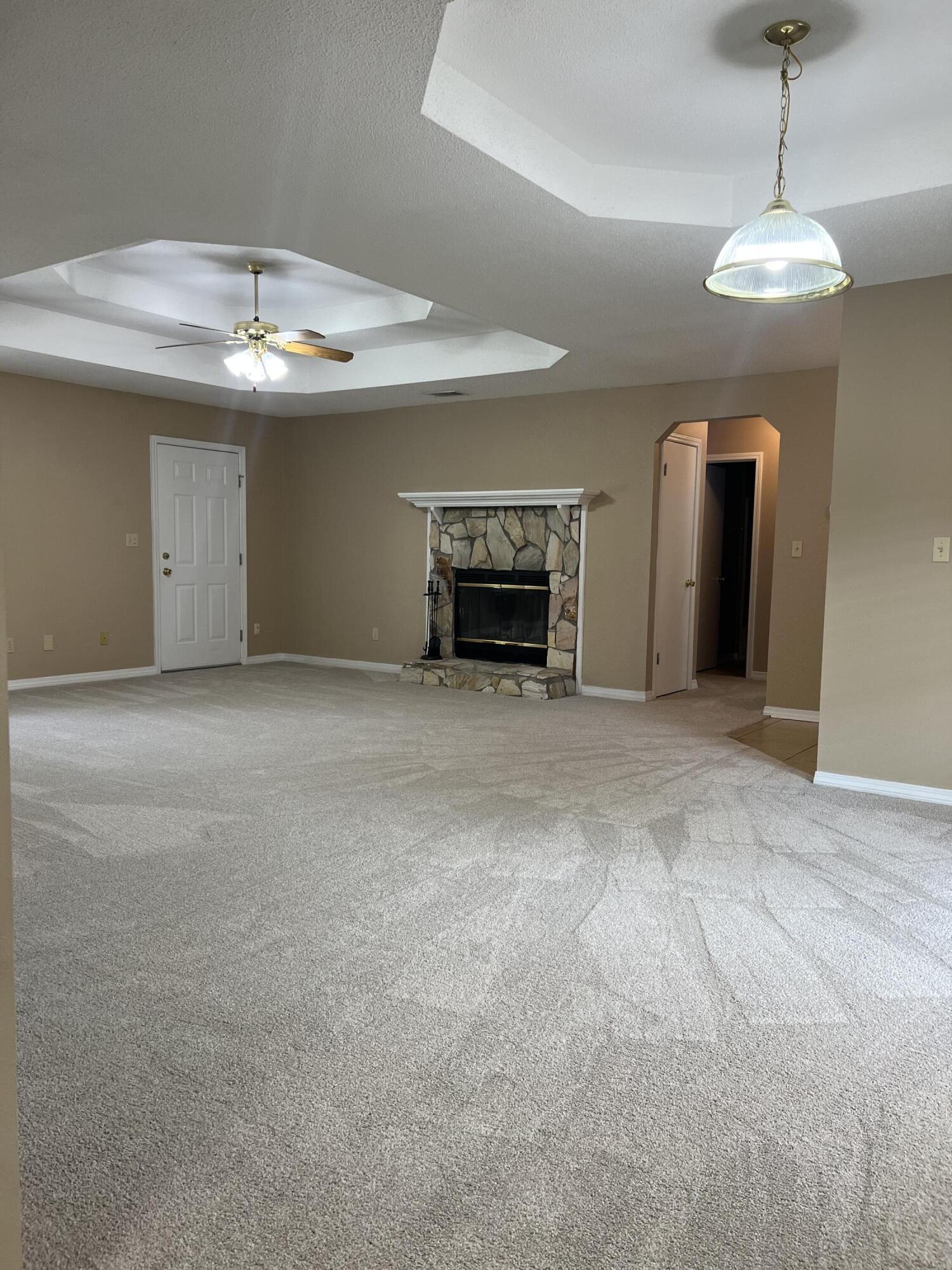 159 Nun Drive Crestview, FL 32536 - Photo 10 of 27 a view of an empty room with a fireplace and a chandelier fan