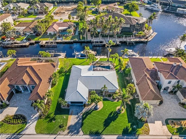 an aerial view of a house with swimming pool and outdoor seating