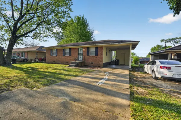 a view of a house with a big yard and large tree