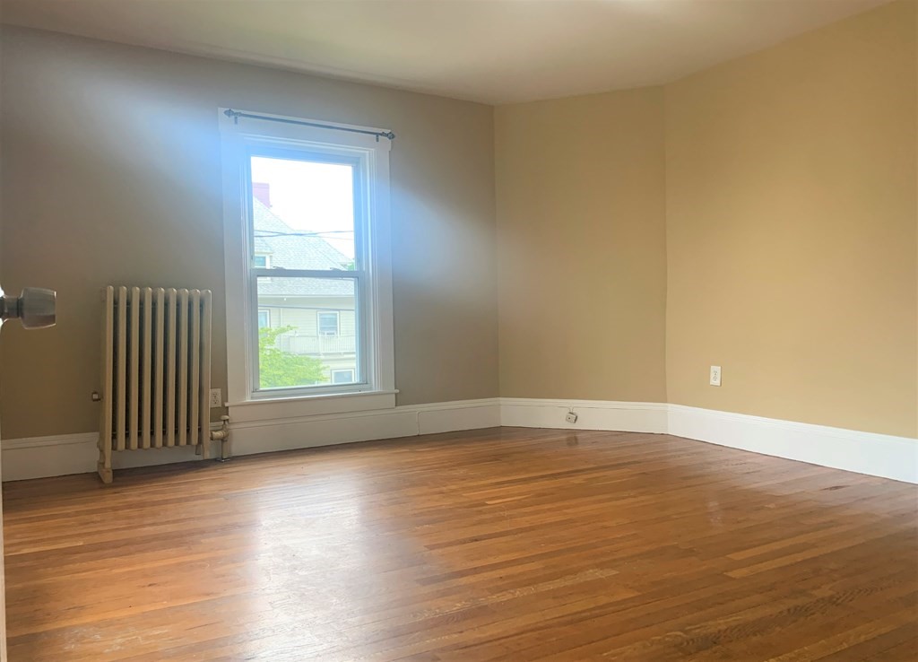 35 5th Street Medford, MA 02155 - Photo 40 of 42 an empty room with wooden floor and windows