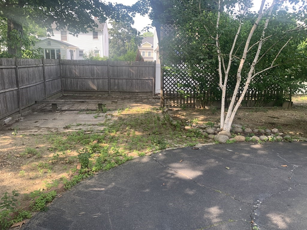 35 5th Street Medford, MA 02155 - Photo 5 of 42 a view of a backyard with large trees and wooden fence