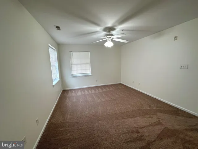 a view of an empty room with a fireplace and a large window