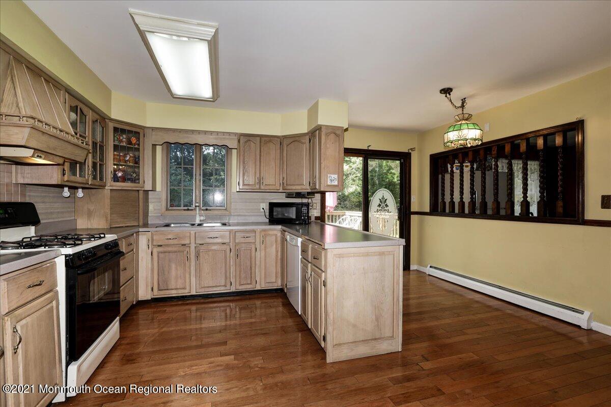 41 Haines Street Lanoka Harbor, NJ 08734 - Photo 13 of 43 a kitchen with granite countertop a stove top oven a sink dishwasher and a refrigerator with wooden floor